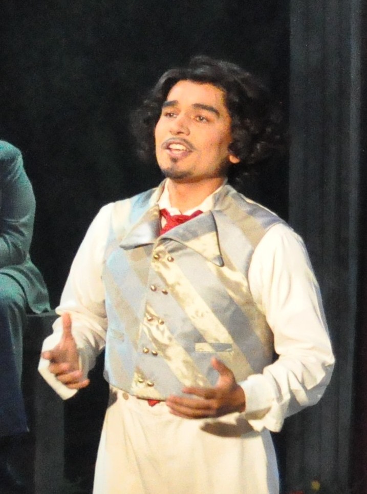 a man wearing a blue and gold striped vest, 3/4 front view, light hits the shiny fabric so that the pattern matching is clear