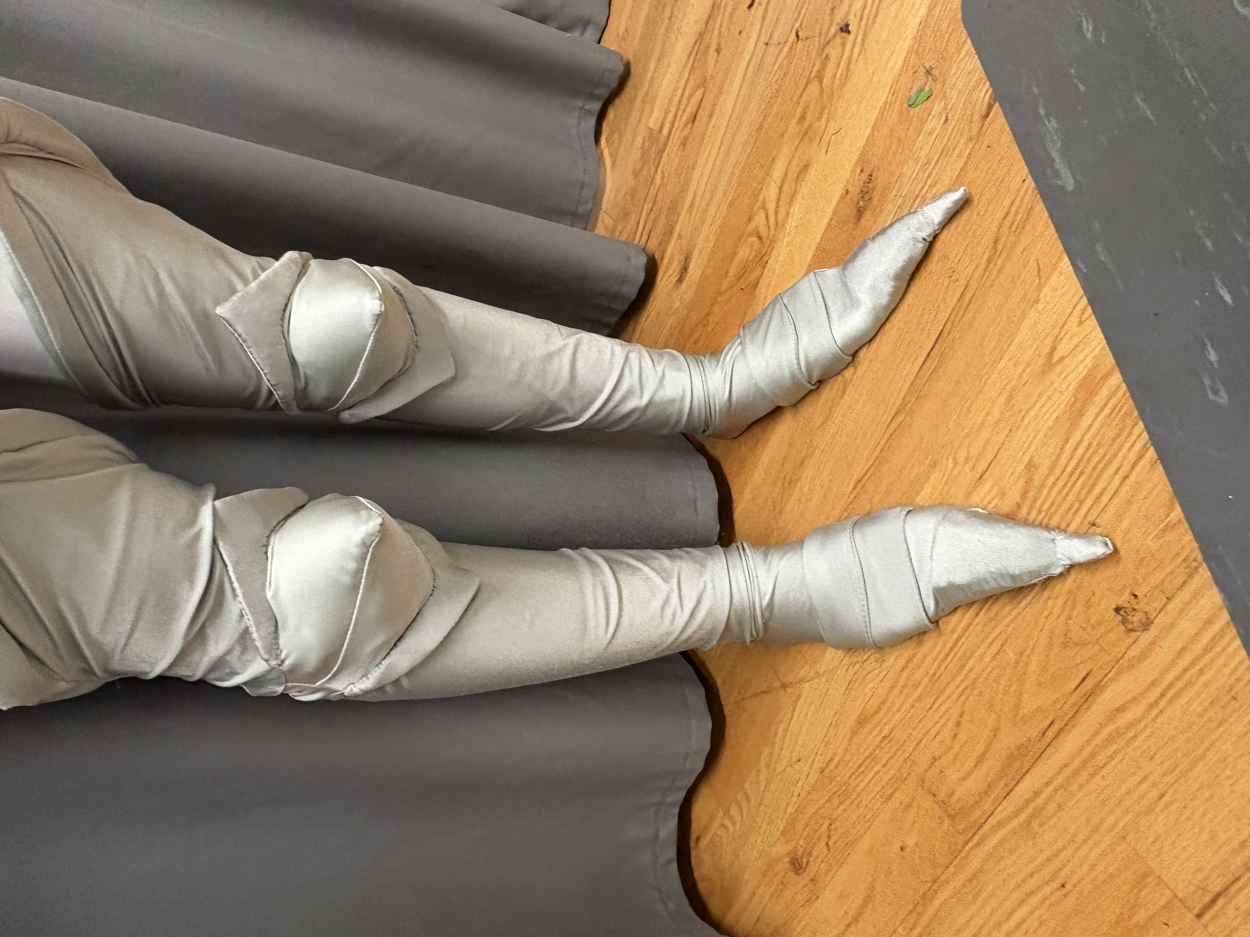 closeup of armor like socks with pointy toes and points at the knees, front view