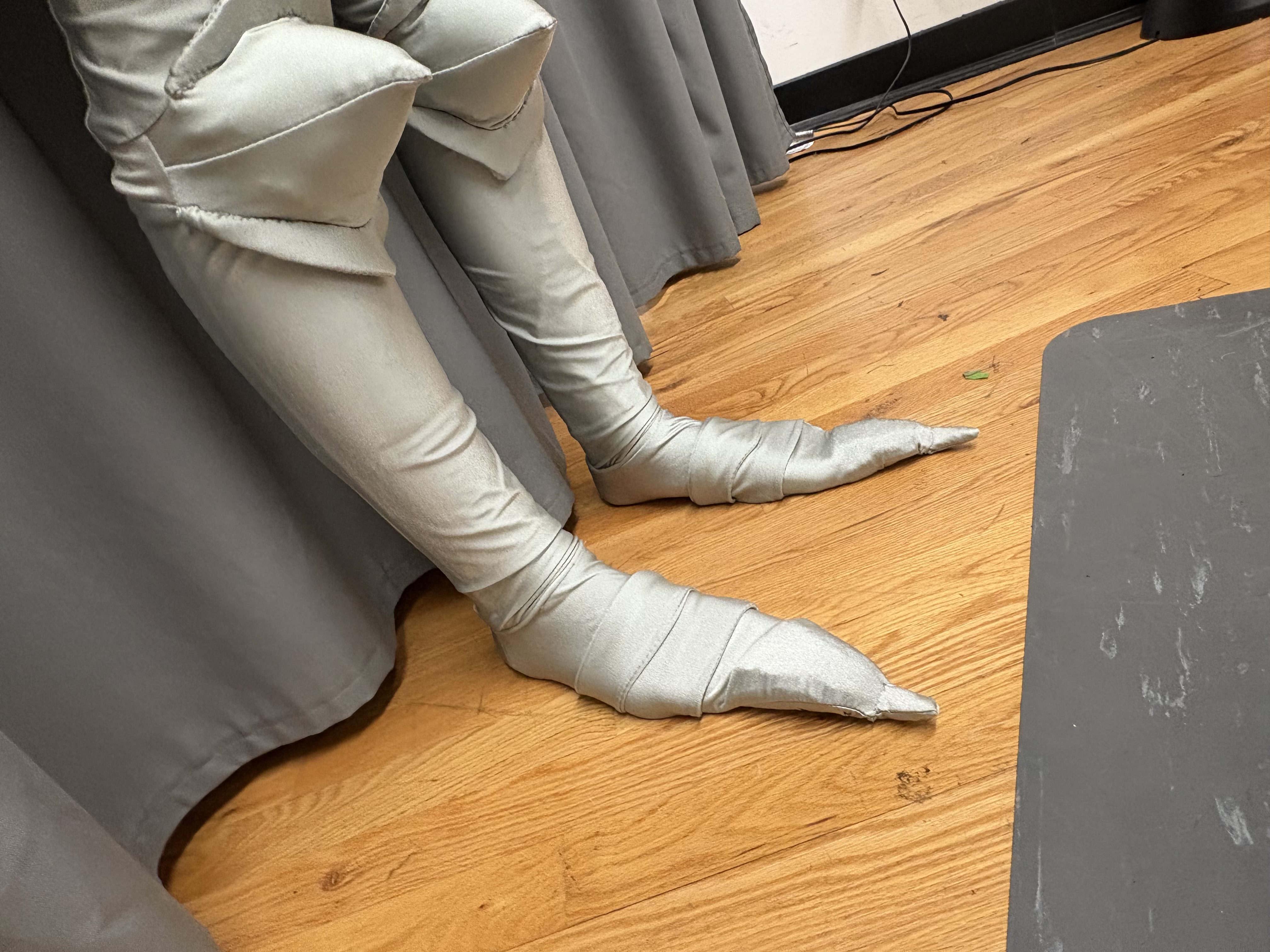 closeup of armor like socks with pointy toes and points at the knees, front view