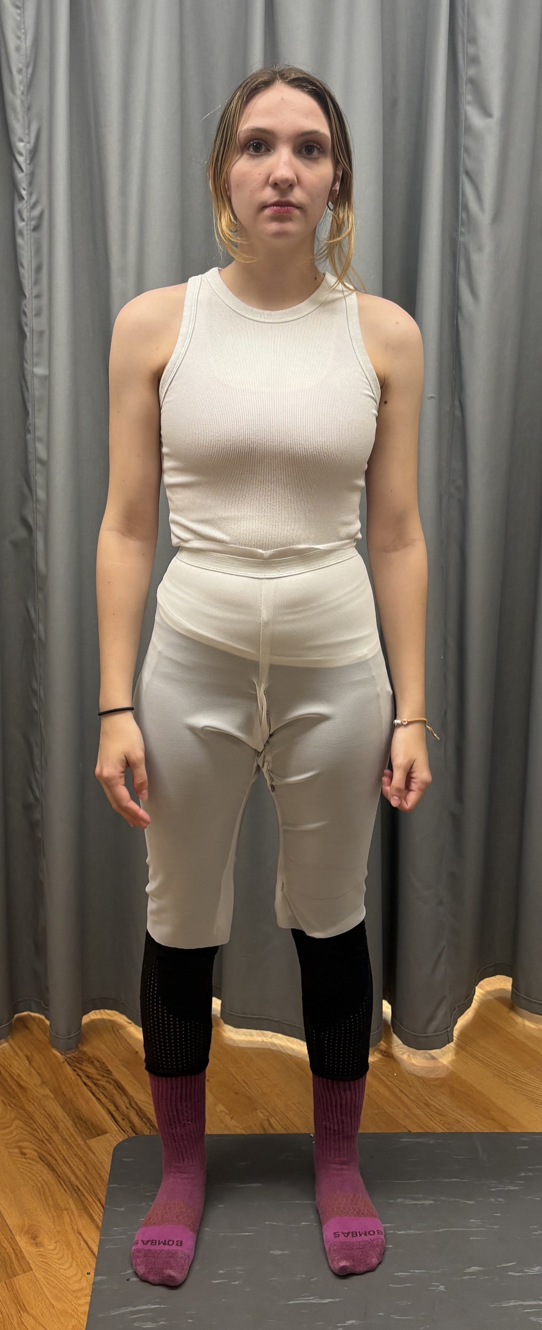 A woman in a camisole and long white bike shorts