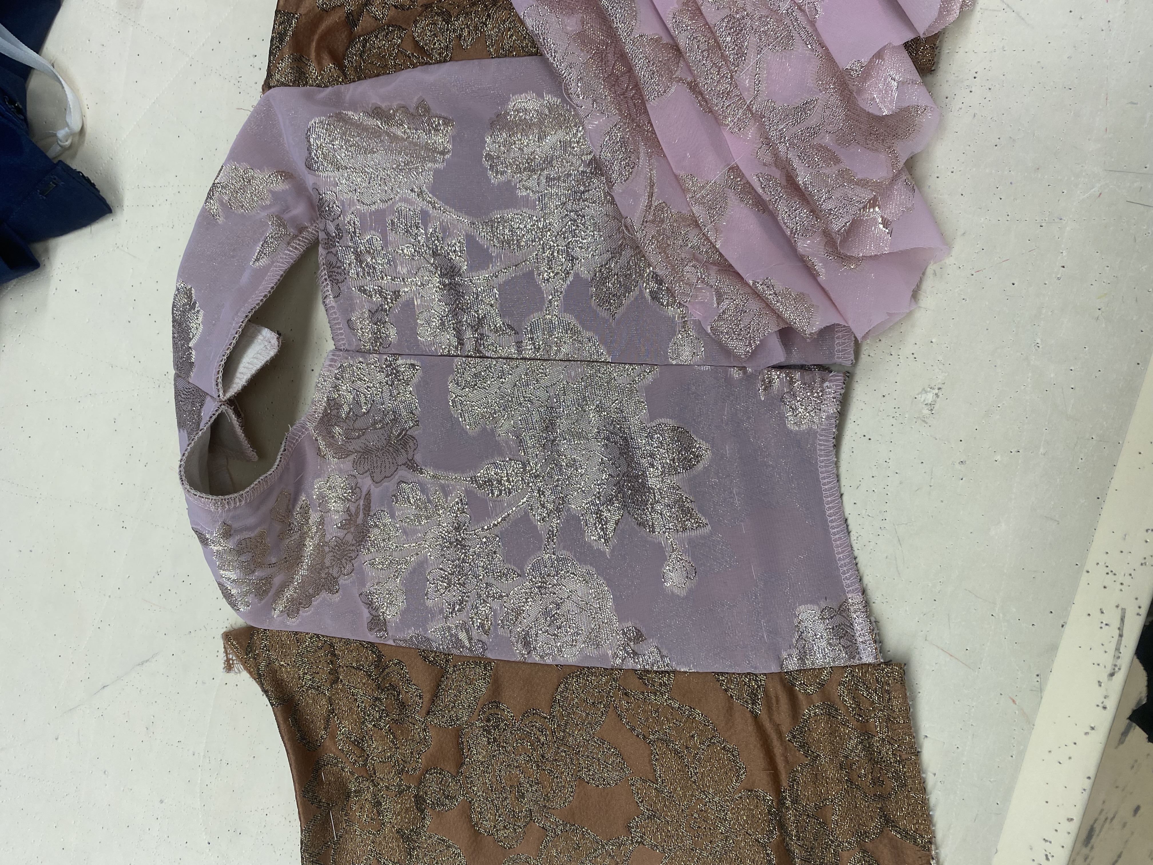 A woman in an edwardian bronze and pink gown, closup of front featuring chiffon drape and ribbon roses