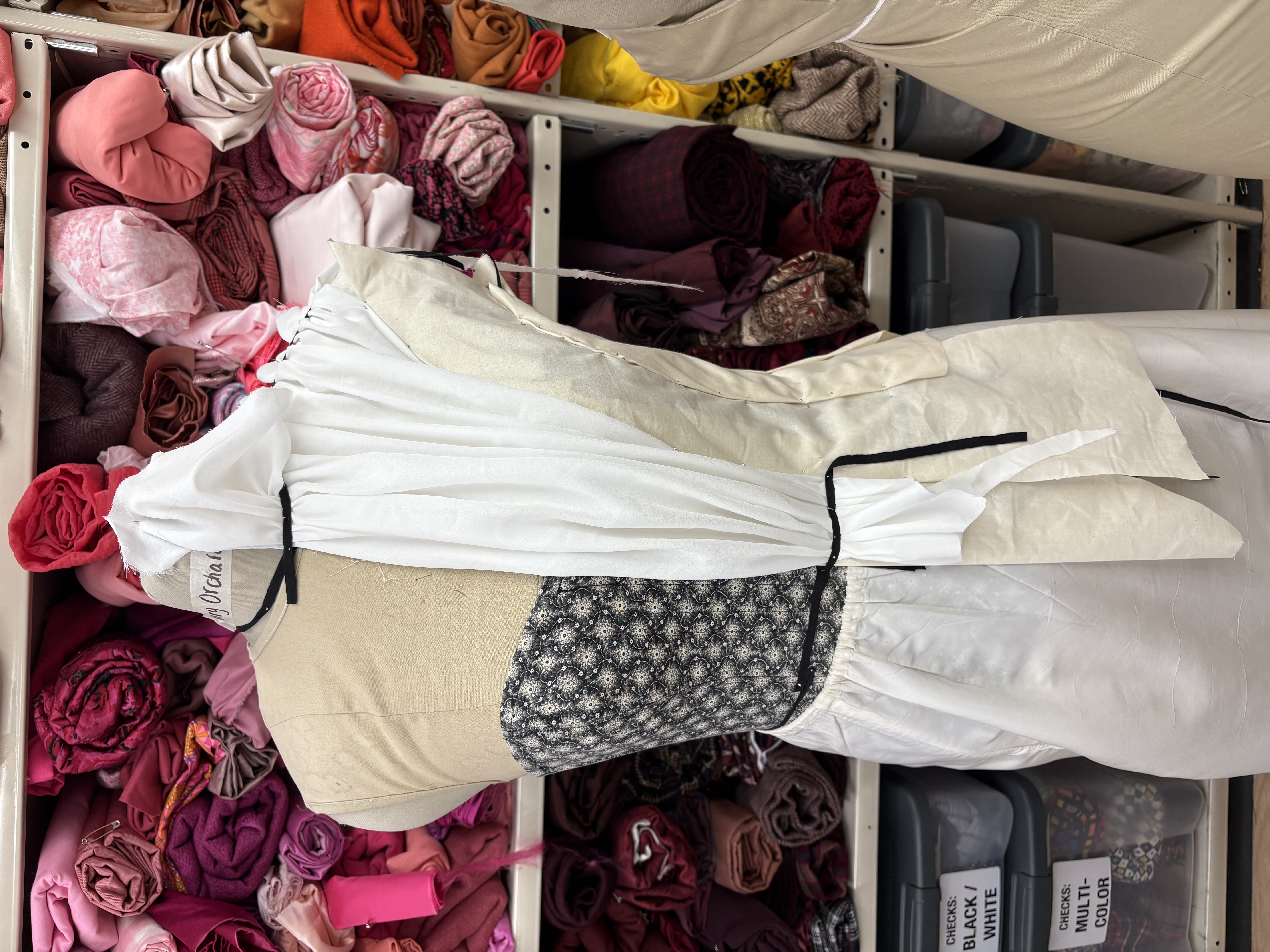 Pattern pieces marked on a dressform with muslin, front view