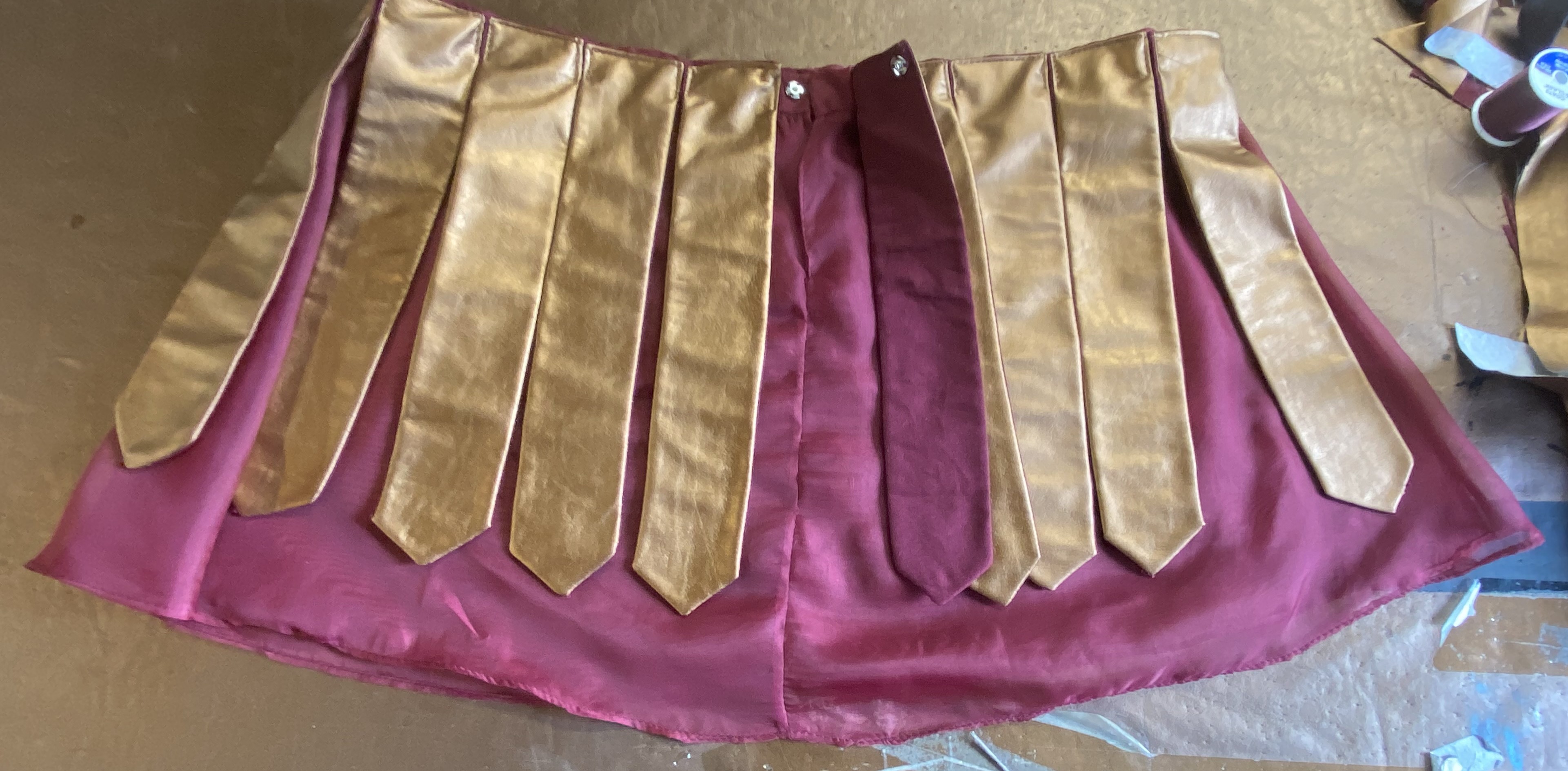 A sheer red skirt with pleather tabs demonstrating the hidden closure