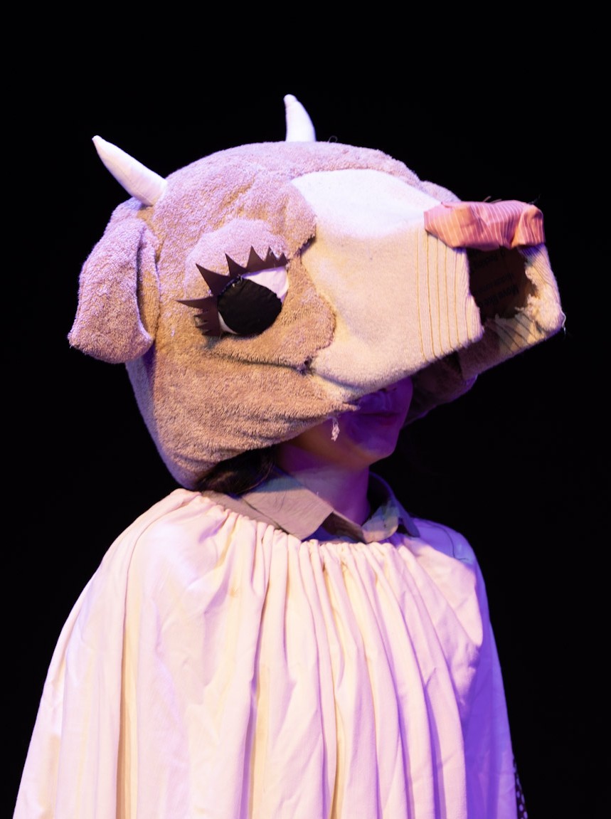 a costume cow head on a woman's head
