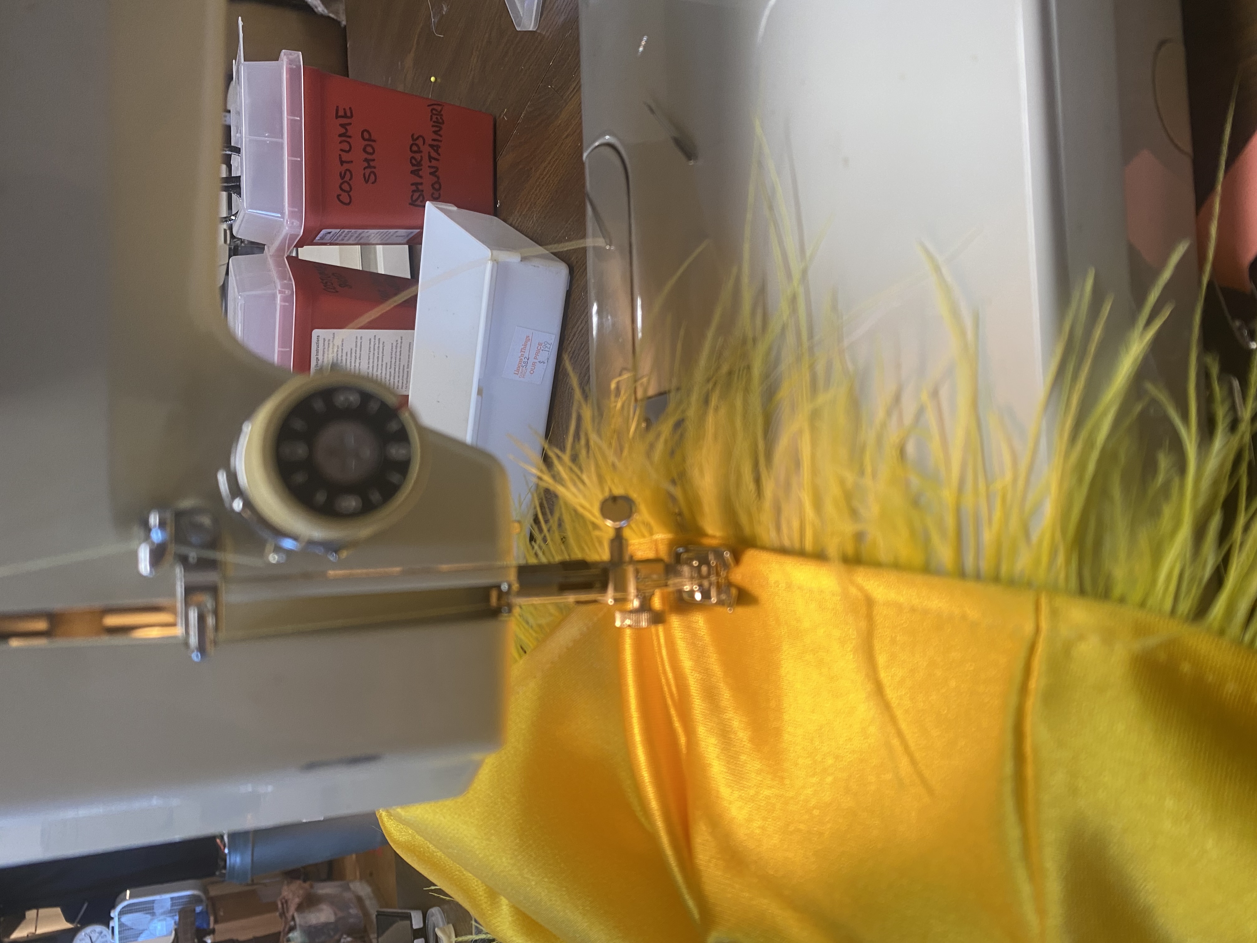 A progress photo of the the feather trimmed hem being sewn
