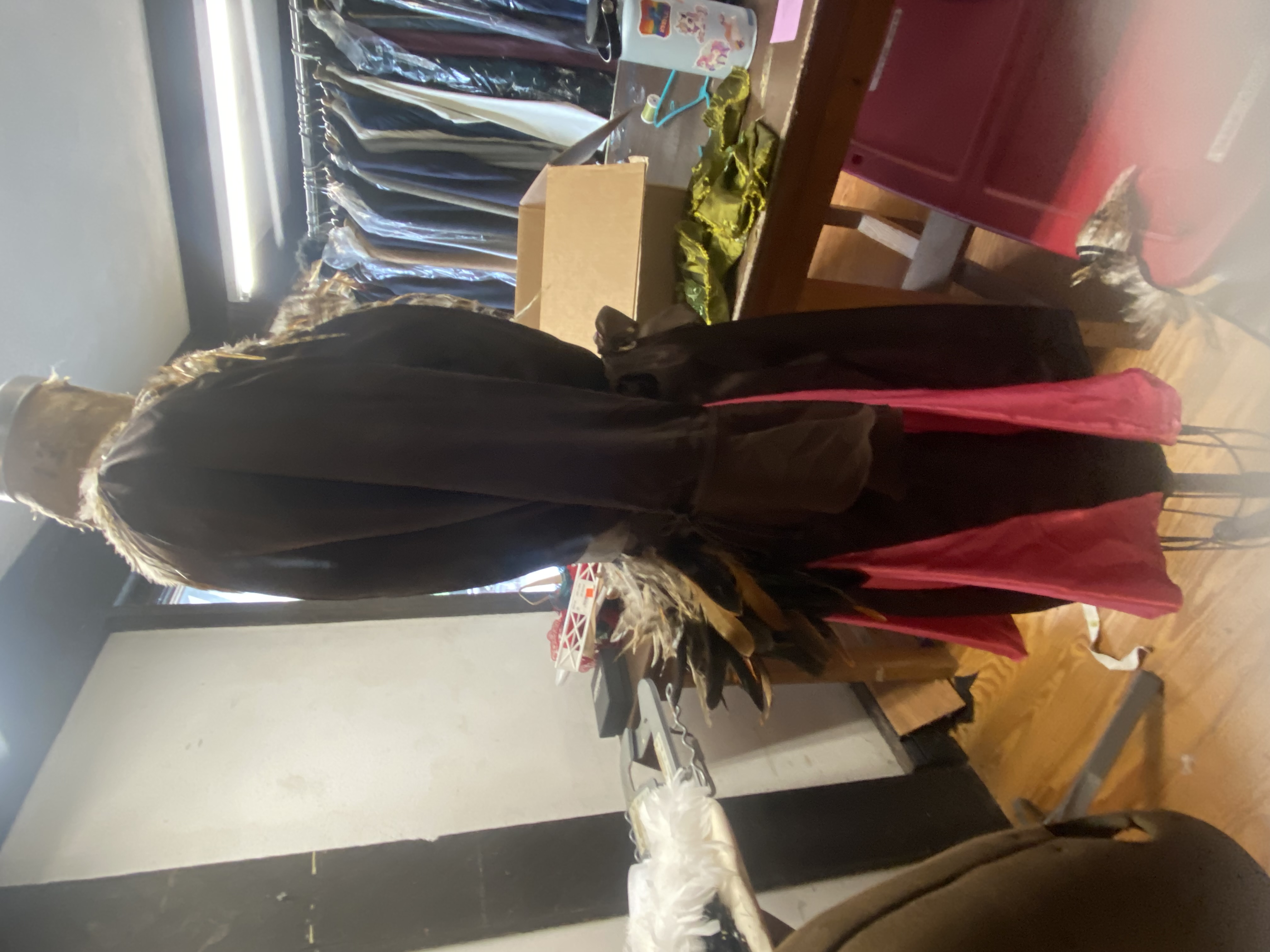 a brown silky dress with a feather bustle, side view