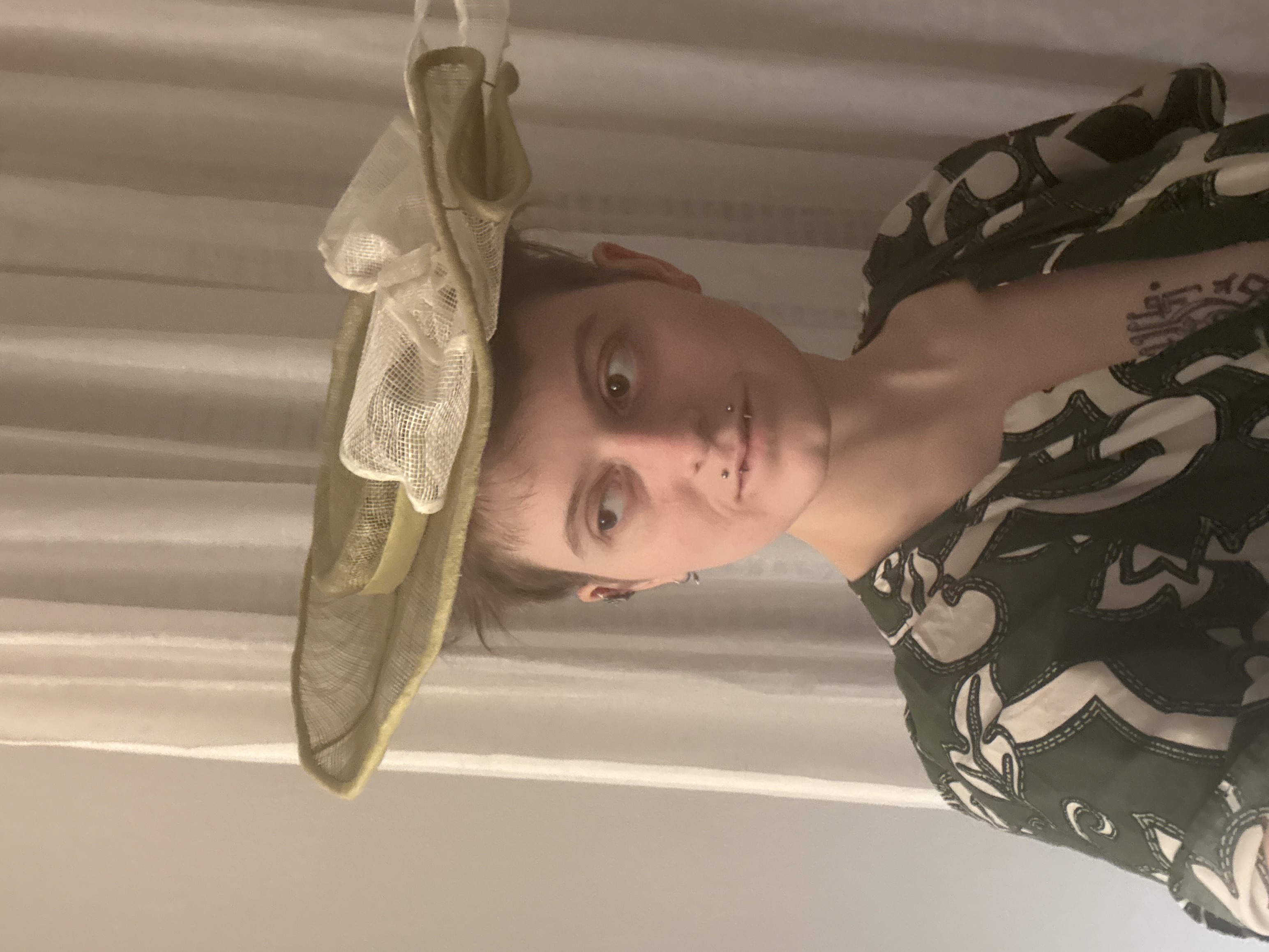 A light green widebrimmed round hat with big white bow, front view