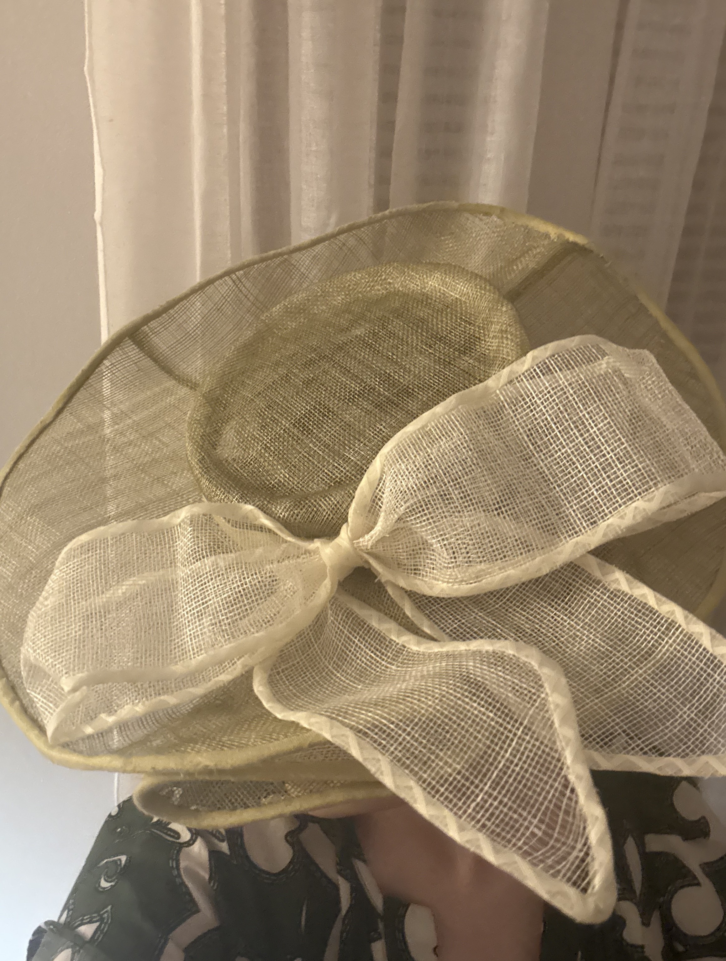 Light green wide brimmed round hat with a large white bow